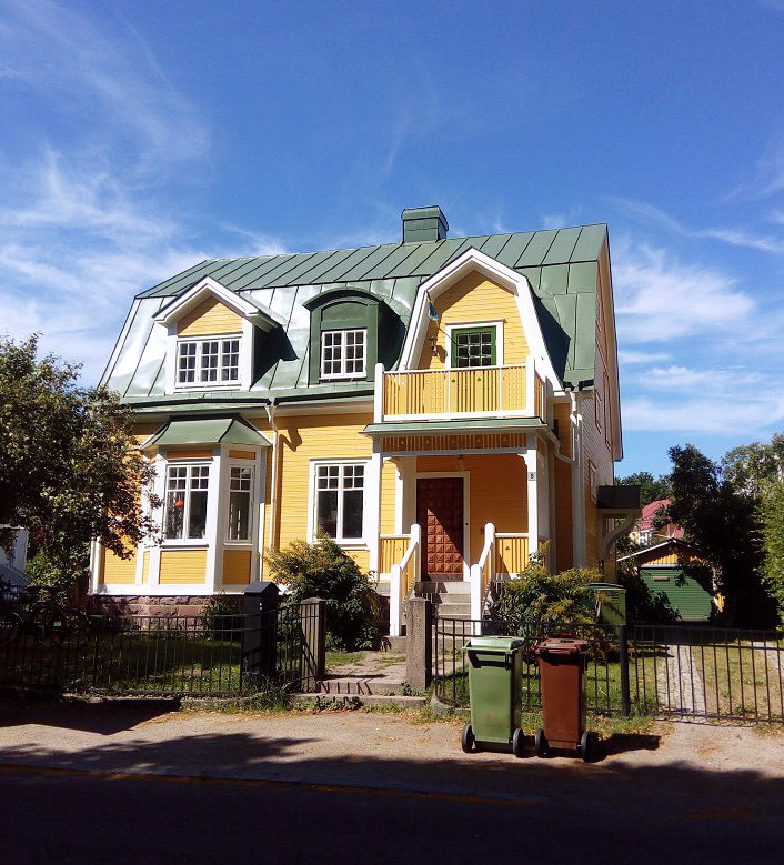 Fasadmålning av gult hus.